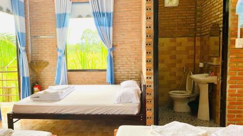 a bedroom with a bed in a brick wall at Nhà Nghỉ Vượn Hót in Tân Phú