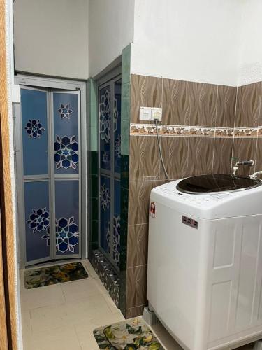 a small bathroom with a washing machine in a room at HOMESTAY AYER MOLEK Malay ONLY in Air Molek