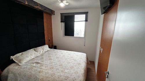 a bedroom with a bed and a window at Cozy apartment in a gated community in Santo André