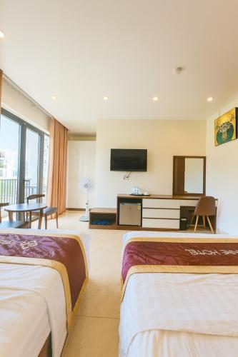 a hotel room with two beds and a flat screen tv at Square Hostel in Ha Long