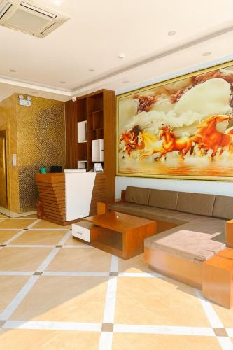 a living room with a painting of horses on the wall at Square Hostel in Ha Long
