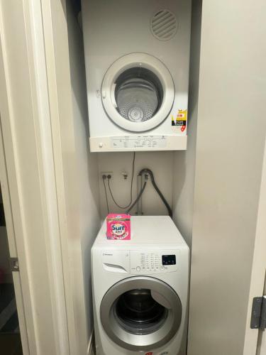 a washing machine and a washer in a small room at Convenient & Comfortable Apartment Suite in Albany in Auckland