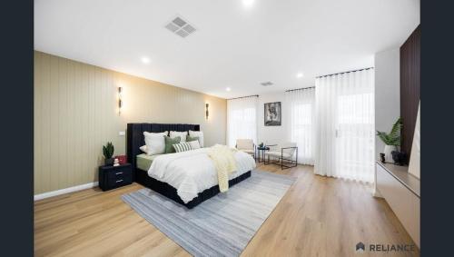 Sunbury home close to Melbourne airport في صَنبري: غرفة نوم بها سرير كبير وغرفة معيشة