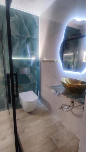 a bathroom with a toilet and a sink in it at Jazmin's Apartments in Oranjestad