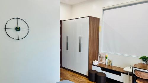 a room with a large white cabinet and a clock at Phòng Double View - Chill với Máy Chiếu, Ban Công Xanh Mát in Thôn Trường Giang