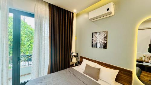 a bedroom with a bed and a large window at Phòng Double View - Chill với Máy Chiếu, Ban Công Xanh Mát in Thôn Trường Giang