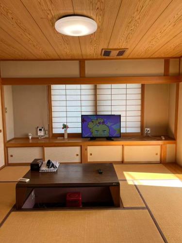 a room with a table and a tv in it at 富士の屋河口湖 in Fujikawaguchiko