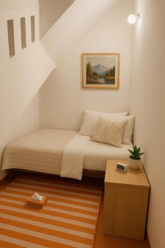 a small bedroom with a bed and a table at Classic Jayanagar House for Veg only in Bengaluru