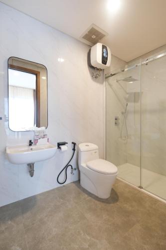 a bathroom with a toilet and a sink and a shower at Bellevue Villa Canggu in Canggu