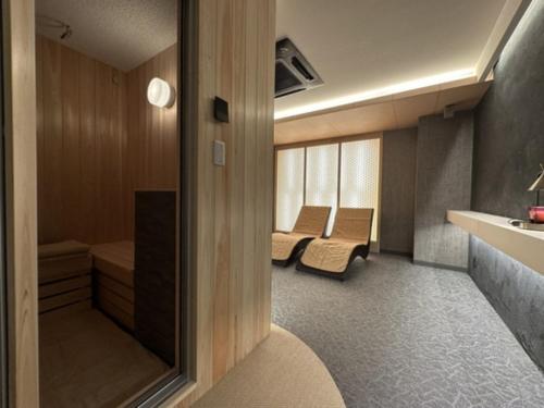 ein kleiner Raum mit zwei Stühlen und einem Waschbecken in der Unterkunft HOTEL felice Osaka Itami Airport - Vacation STAY 54182v in Toyonaka