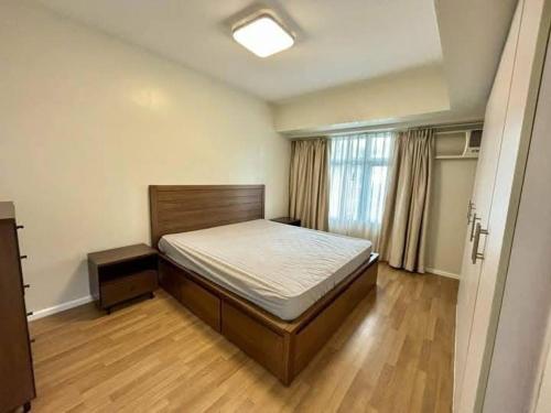een slaapkamer met een bed en een houten vloer bij Sweethome in Manilla