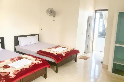 Zimmer mit 2 Betten und roter Bettwäsche in der Unterkunft Bảo Minh Motel Đông Hà in Quang Tri