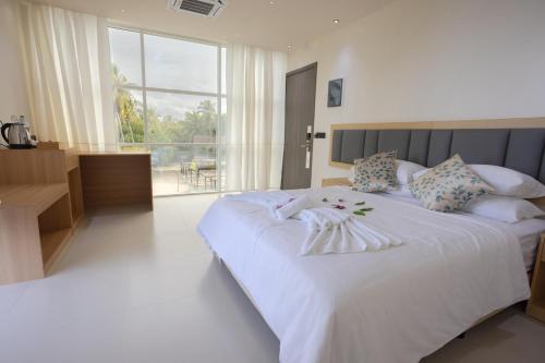 ein Schlafzimmer mit zwei Betten und einem großen Fenster in der Unterkunft Aqua Luna Dhangethi in Dhangethi