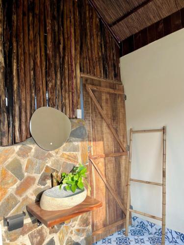 a room with a stone wall and a potted plant at Sora Traditional Homestay in Ninh Binh