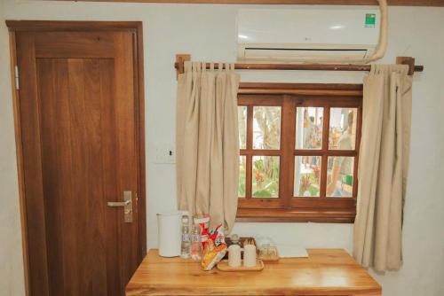 eine Küche mit Fenster und Holztisch in der Unterkunft Lalagigi Homestay in La Gi