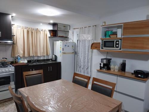 eine kleine Küche mit Tisch und Mikrowelle in der Unterkunft Refugio entre el Lago y el Mar in Mar de Cobo