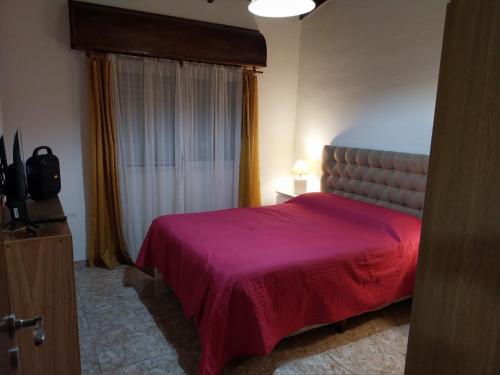 ein Schlafzimmer mit einem roten Bett und einem Fenster in der Unterkunft Refugio entre el Lago y el Mar in Mar de Cobo