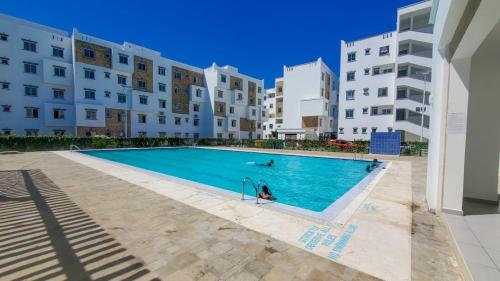 a swimming pool in front of some buildings at Giannas stays 2br in Mombasa