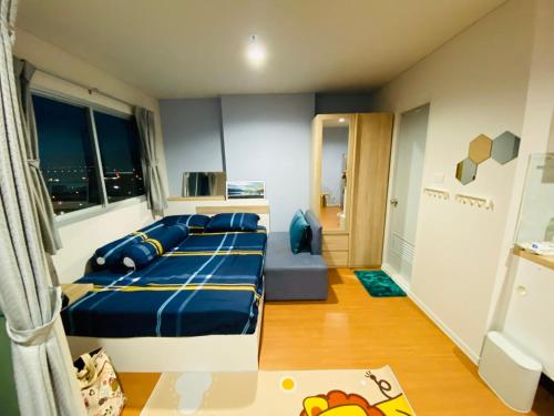 een slaapkamer met een bed met blauwe kussens bij LPN Seaview Cha-am in Ban Phu Wai