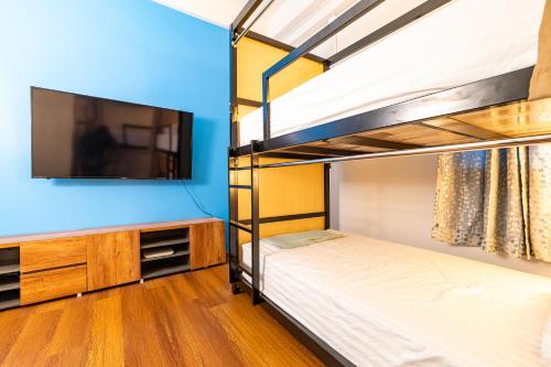 a bedroom with two bunk beds and a flat screen tv at Queen On Street 2009 in Ban Lo Long