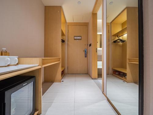 una cucina con armadi in legno e un corridoio di JI Hotel Chengdu Tianfu Square a Chengdu