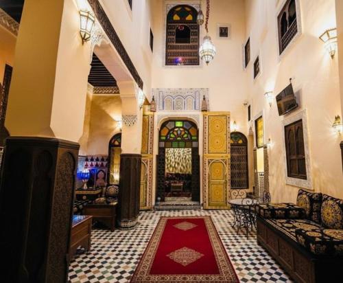 a lobby of a building with a red rug on the floor at Riad Fez Panorama in Fès