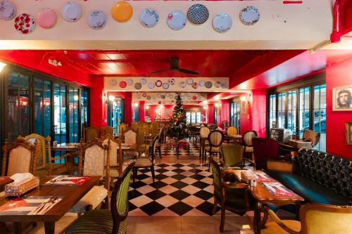 Un restaurante con paredes rojas, mesas y sillas. en The Quba Boutique Hotel Pattaya, en Pattaya central