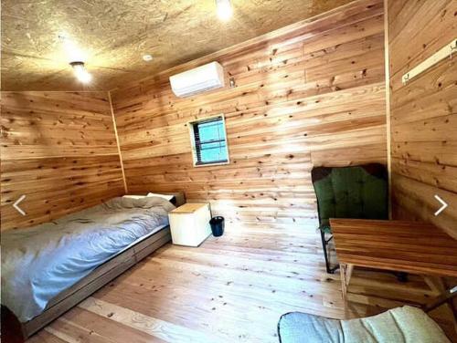 a room with a bed and a wooden wall at Our Minano Base - Vacation STAY 92839v in Minano