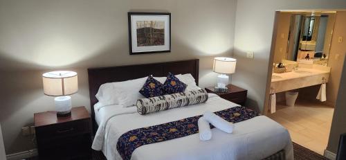 a bedroom with a bed and a bathroom with a sink at King Bed, Balcony, Pool, Hot Tub, Sauna in Edgar