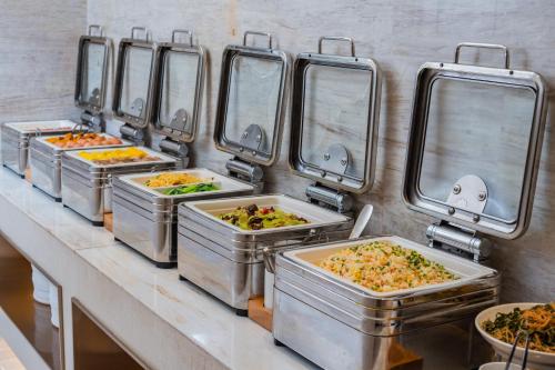 una fila di vassoi di cibo su un bancone di JI Hotel Chengdu Tianfu Square a Chengdu