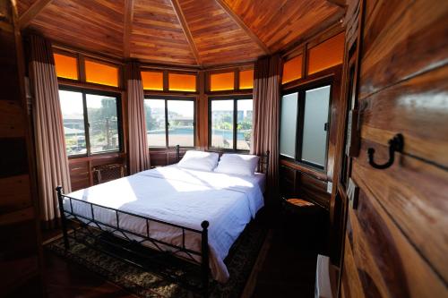 a bedroom with a bed in a room with windows at BaanPranwadee in Ban Na Kai