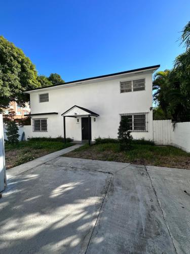 a white building with a driveway in front of it at CG Miami House in Miami