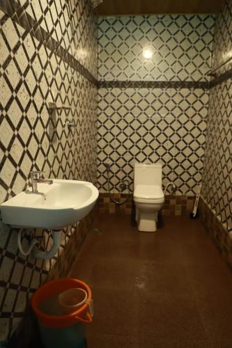 ein Badezimmer mit Waschbecken und Toilette in der Unterkunft Mountain Shadows in Devikolam