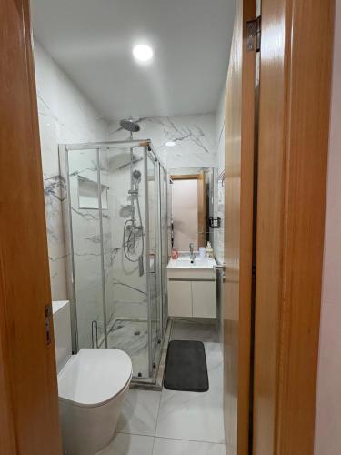 a bathroom with a shower and a toilet and a sink at Apartamento Batuku in Praia