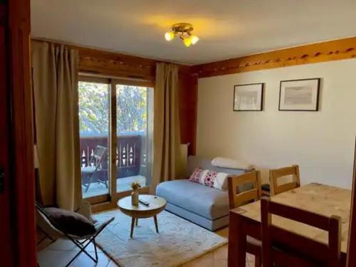 a living room with a couch and a table at Appartement à Méribel 4 pers, piscine, skis aux pieds - FR-1-411-1007 in Chandon