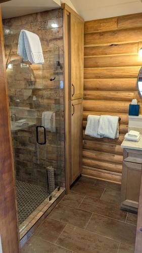 a shower with a glass door in a bathroom at The Willows Cabins in West Yellowstone