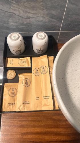 two rolls of toilet paper on a tray next to a sink at Avana House in Nguyên Ngoại
