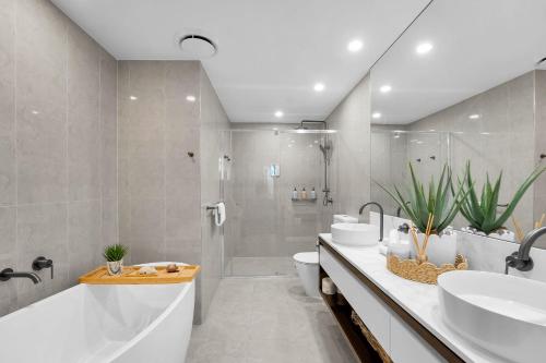 a bathroom with a tub and a sink and a shower at The Gallery Residences Broadbeach - Official Listing in Gold Coast