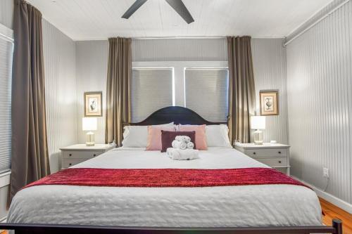 a teddy bear sitting on a bed in a bedroom at Be A Nomad - Historic 6BR Cottage Steps to Jacksonville Beach Sleeps 12 in Jacksonville Beach