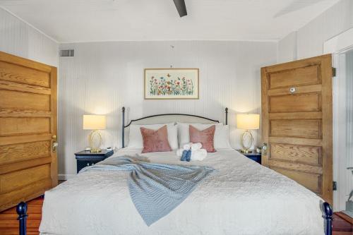 a bedroom with a large bed with two lamps at Be A Nomad - Historic 6BR Cottage Steps to Jacksonville Beach Sleeps 12 in Jacksonville Beach