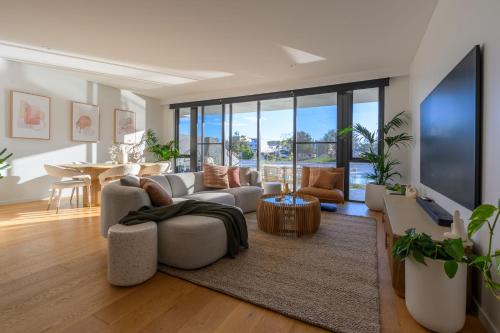 a living room with a couch and a tv at Maraboo Island - Luxury, Beachfront, family friendly, Sauna, close to Fremantle & Rottnest Island Ferry in Coogee