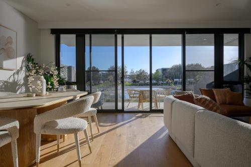 a living room with a couch and a table and chairs at Maraboo Island - Luxury, Beachfront, family friendly, Sauna, close to Fremantle & Rottnest Island Ferry in Coogee