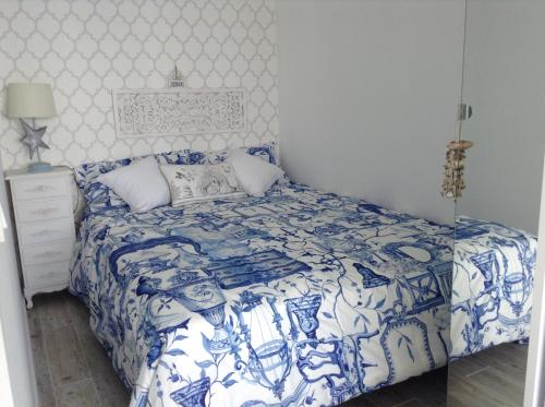 1 dormitorio azul y blanco con 1 cama con manta azul y blanca en Sun & Sea 511, en Sesimbra