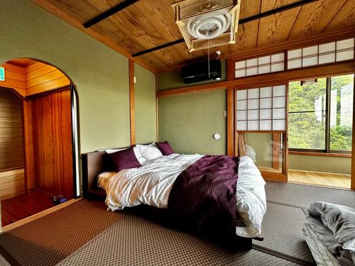 a bedroom with a bed in the corner of a room at 海の宿mare in Hakui