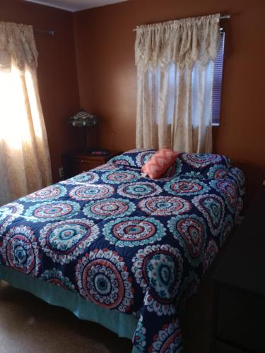 een slaapkamer met een bed met een blauw-witte deken bij 1 BEDROOM KITCHEn BATHROOM ApT in Titusville