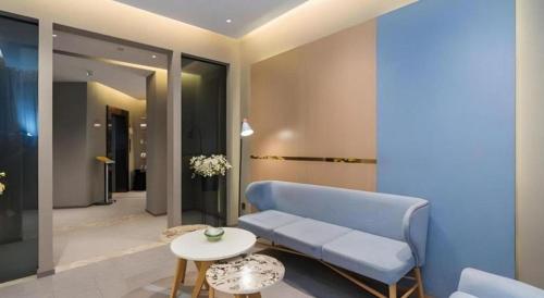 ein Wohnzimmer mit einem blauen Sofa und einem Tisch in der Unterkunft Home Inn Neo Leshan Central Food Street in Leshan