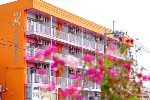 an orange building with pink flowers in front of it at Hotel Resort Inn Ishigakijima in Ishigaki Island