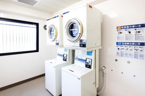 a laundry room with washing machines and a window at 伊万里リバティホテル in Imari