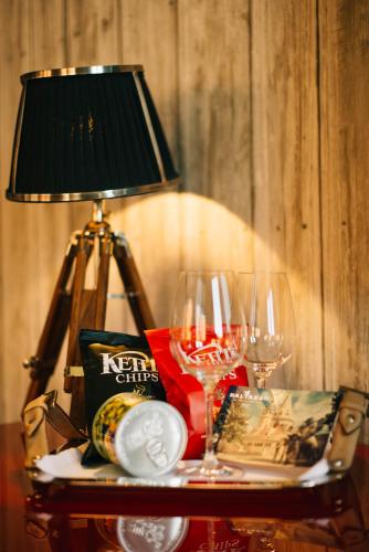 a table with two wine glasses and a lamp on it at BALTAZÁR Boutique Hotel in Budapest