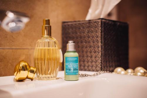 a bottle of soap sitting on a bathroom sink at BALTAZÁR Boutique Hotel in Budapest